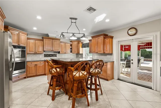 a kitchen with stainless steel appliances granite countertop a stove top oven a sink a counter space and cabinets