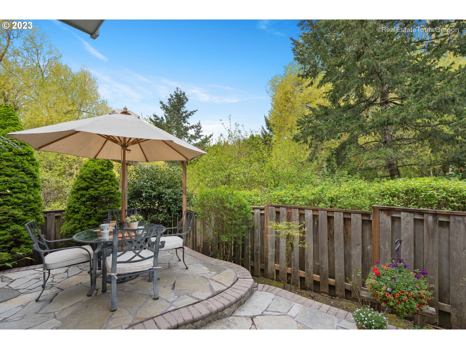 14345 Holly Springs Road Lake Oswego, OR 97035 - Photo 29 of 32 a backyard of a house with table and chairs under an umbrella