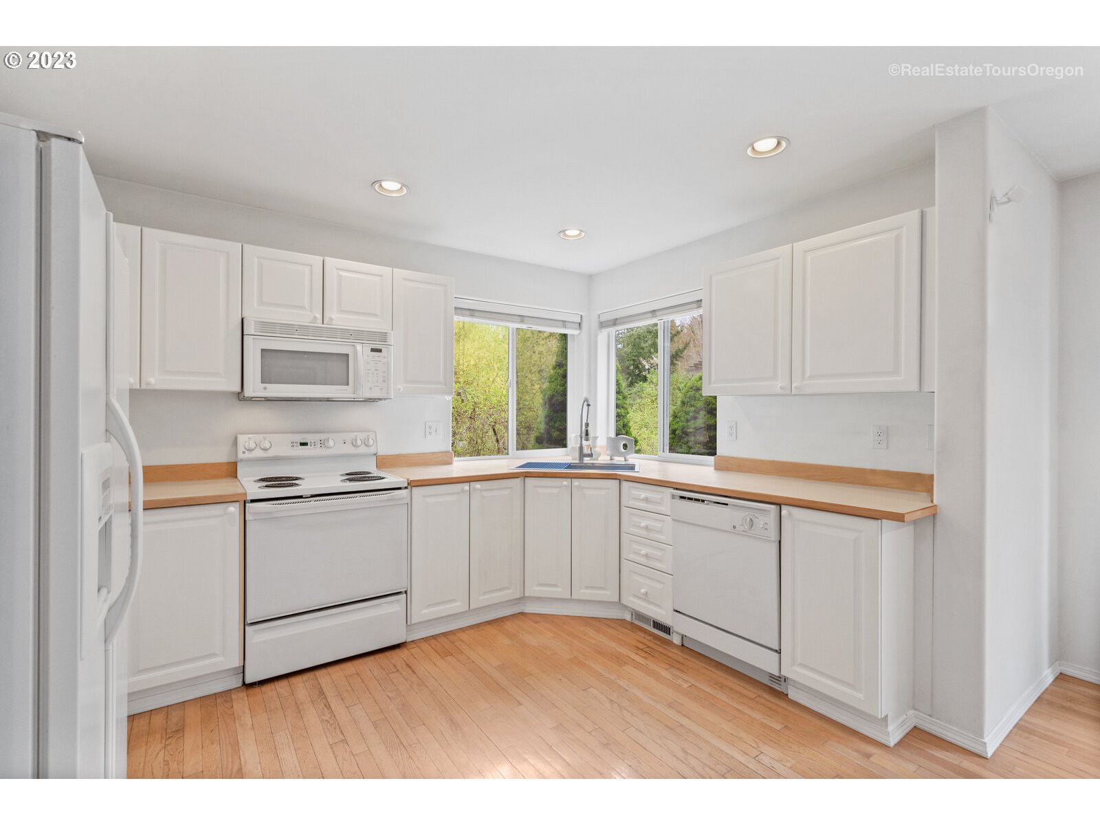 14345 Holly Springs Road Lake Oswego, OR 97035 - Photo 5 of 32 a kitchen with granite countertop white cabinets and white appliances