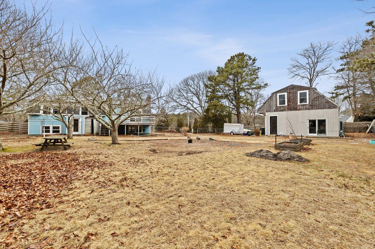 1460 Massasoit Road Eastham, MA 02642 - Photo 40 of 42 a front view of a house with a yard covered with snow and trees