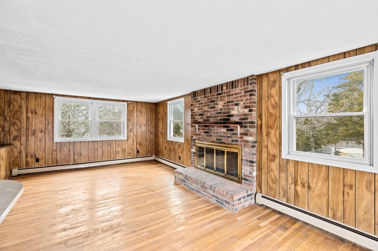 1460 Massasoit Road Eastham, MA 02642 - Photo 10 of 42 a view of an empty room with a fireplace and a window