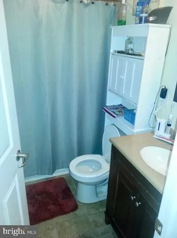 a bathroom with a granite countertop sink toilet and a mirror
