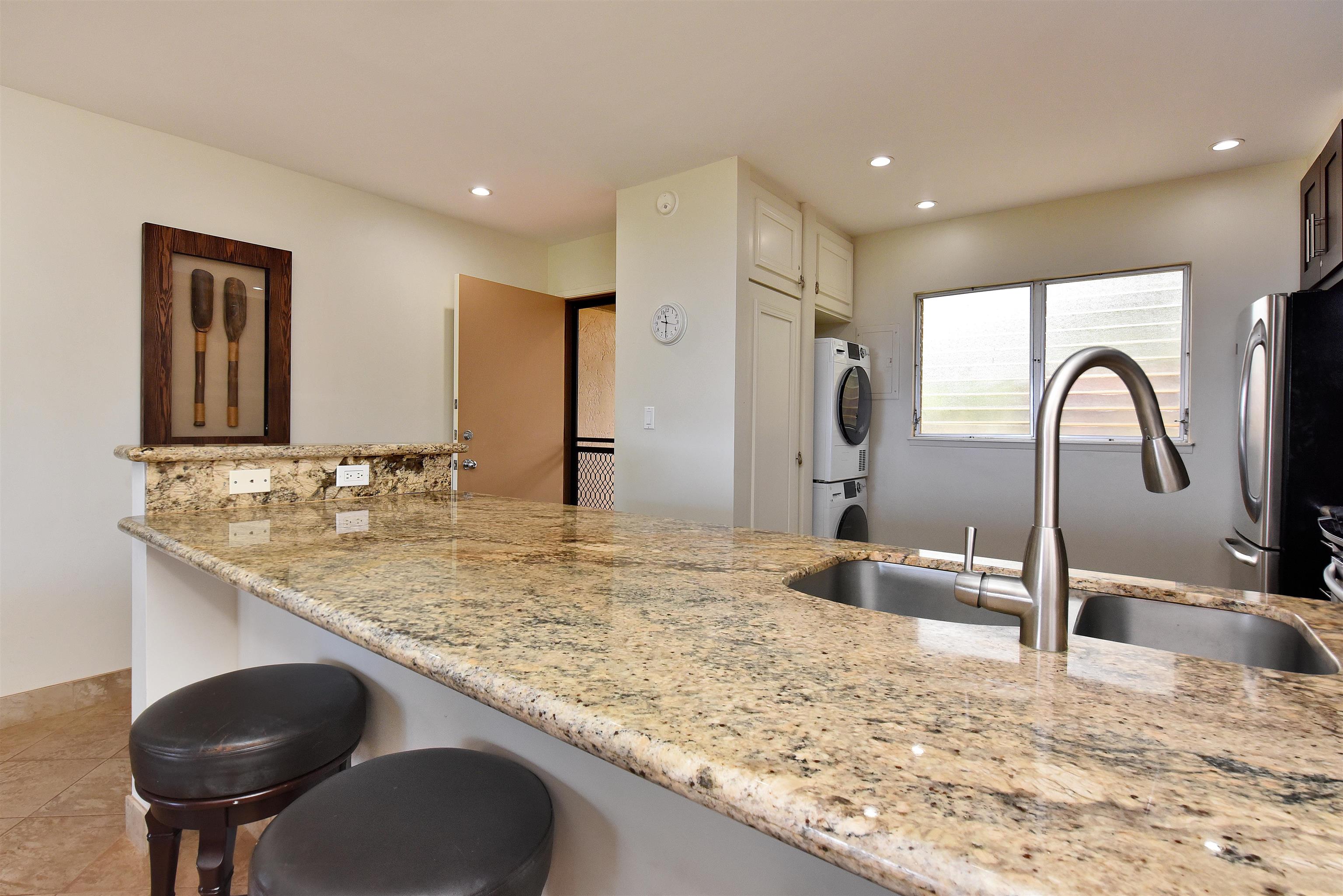 150 Puukolii Road, Unit 52 Lahaina, HI 96761 - Photo 9 of 50 a kitchen with kitchen island a sink and a refrigerator