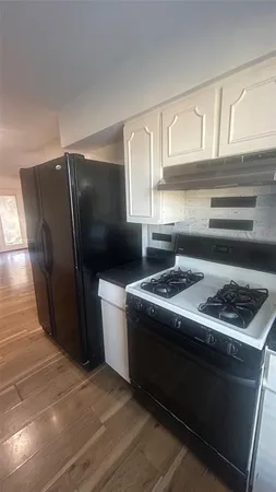 a kitchen with granite countertop a stove and a refrigerator