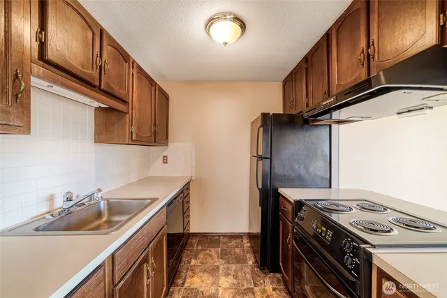 a kitchen with stainless steel appliances granite countertop a sink stove and refrigerator