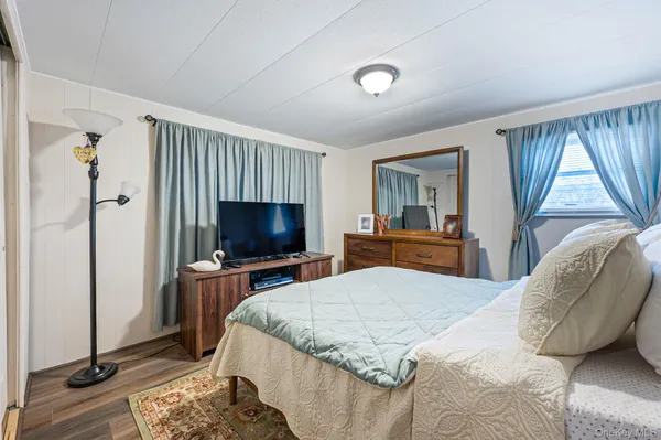a bedroom with a bed and a flat screen tv