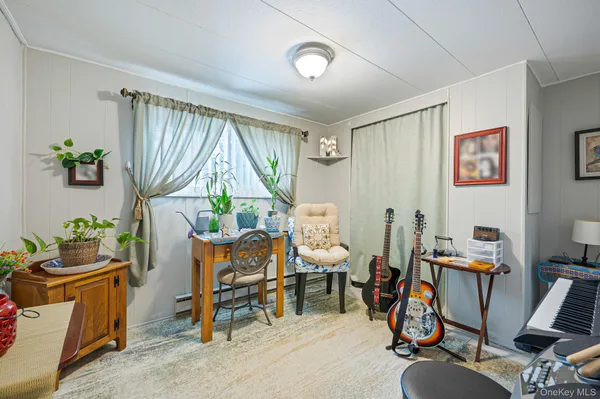 a view of a workspace with furniture and a window