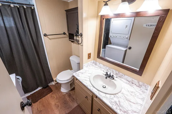 a bathroom with a sink a toilet a mirror and shower curtain