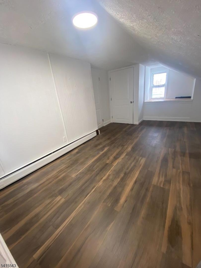 61 Highland Street Paterson, NJ 07524 - Photo 6 of 13 an empty room with wooden floor and windows