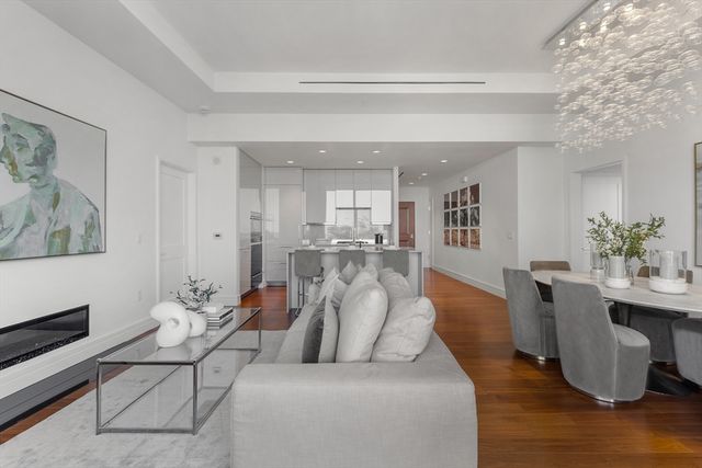a living room with furniture and a dining table with wooden floor
