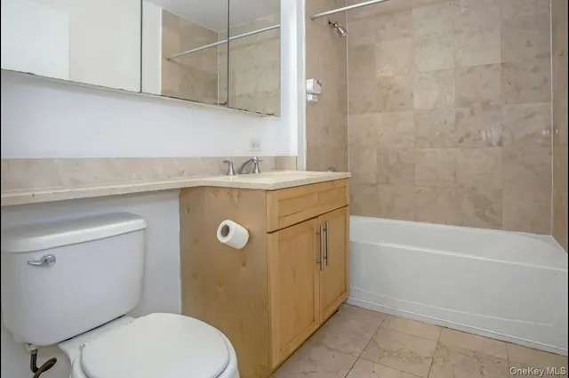 a bathroom with a granite countertop toilet a sink and bathtub
