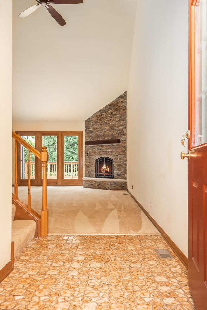 466 River Front Circle Naperville, IL 60540 - Photo 3 of 17 an empty room with fireplace and windows