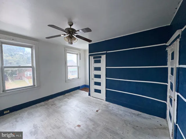 a view of an empty room with a window and a ceiling fan