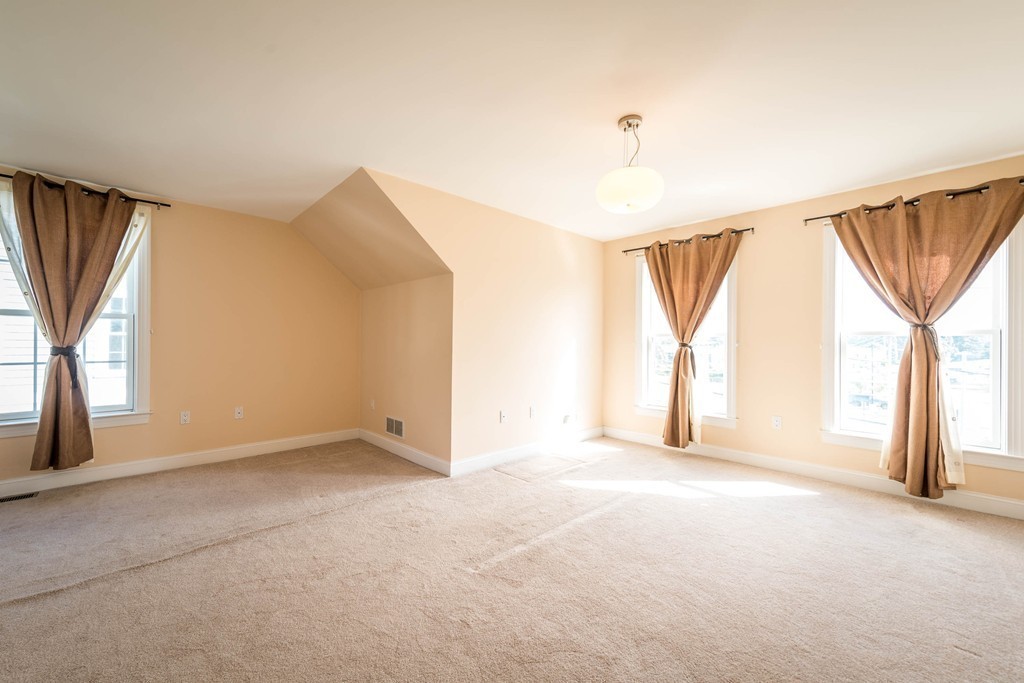 97 Boardman Street, Unit 97 Boston, MA 02128 - Photo 12 of 18 a view of an empty room with a window and a kitchen