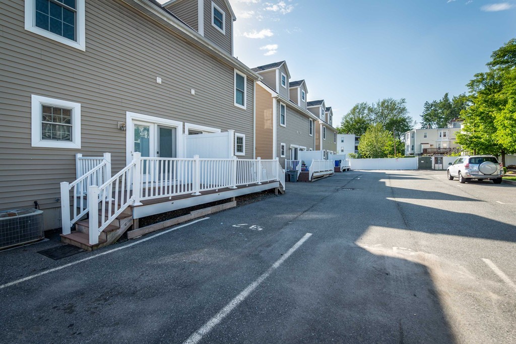 97 Boardman Street, Unit 97 Boston, MA 02128 - Photo 16 of 18 a view of a house with a yard and wooden fence