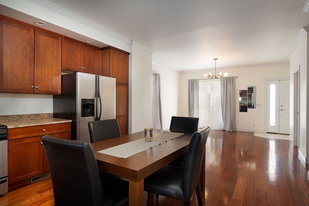 97 Boardman Street, Unit 97 Boston, MA 02128 - Photo 2 of 18 a kitchen with stainless steel appliances wooden floor dining table and chairs