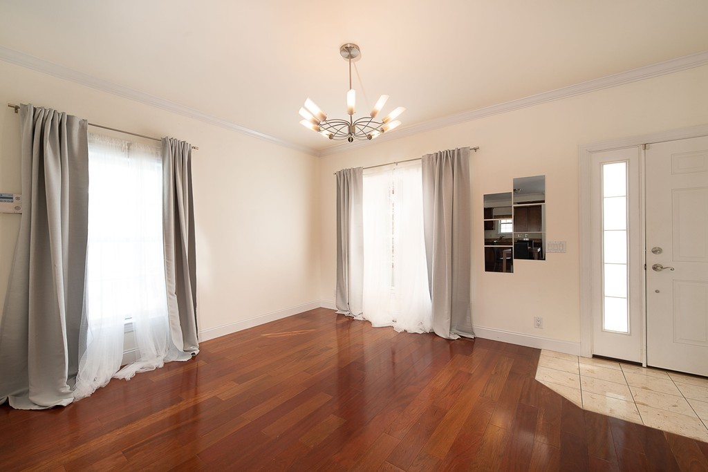 97 Boardman Street, Unit 97 Boston, MA 02128 - Photo 5 of 18 wooden floor in an empty room with a window