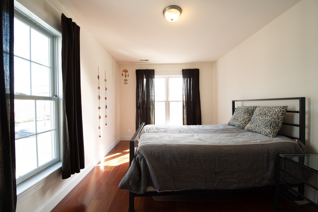 97 Boardman Street, Unit 97 Boston, MA 02128 - Photo 10 of 18 a bedroom with a bed and a large window