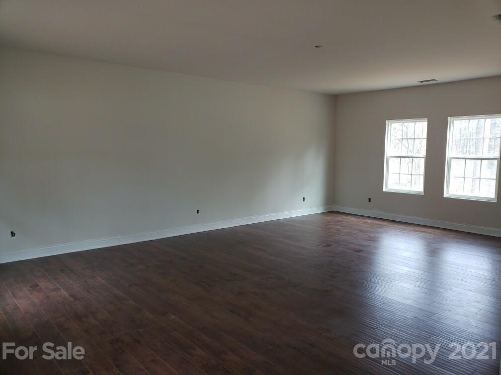 1806 Love Road Monroe, NC 28110 - Photo 8 of 20 an empty room with wooden floor and windows