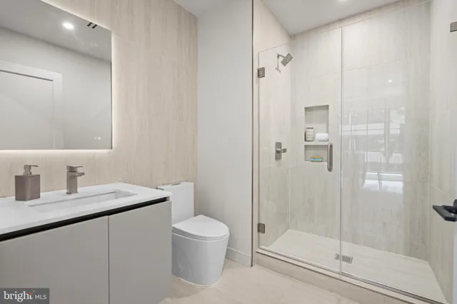 a bathroom with a granite countertop sink a toilet and shower