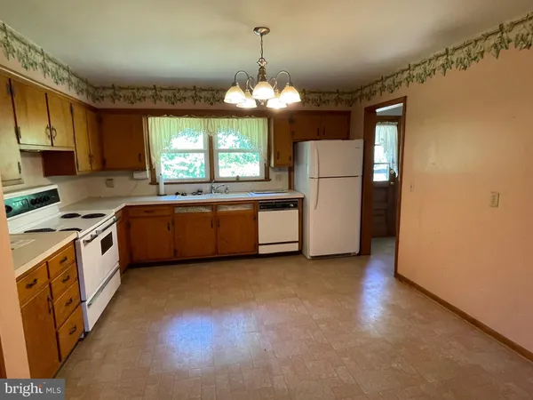 a kitchen that has a lot of cabinets and stainless steel appliances