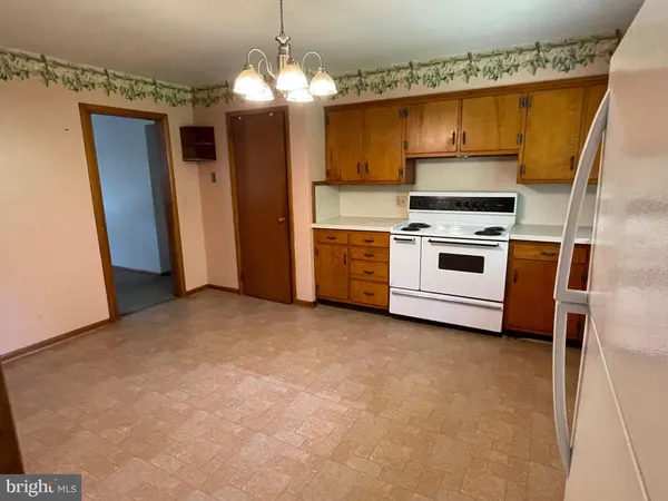 a kitchen with a sink stainless steel appliances a refrigerator and a fireplace