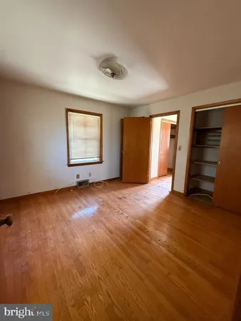 an empty room with windows and closet