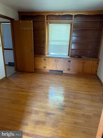 a view of a room with wooden floor and cabinet