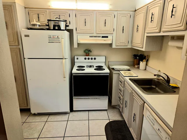 a kitchen with a refrigerator sink stove and cabinets