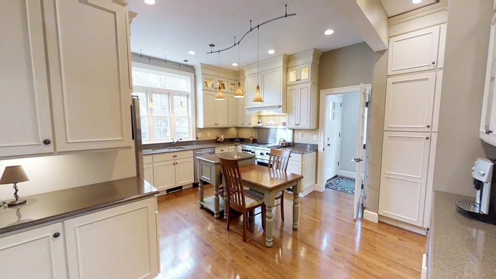 35 Renwick Road Melrose, MA 02176 - Photo 9 of 27 a kitchen with stainless steel appliances granite countertop a stove a refrigerator a sink a dining table and chairs with wooden floor