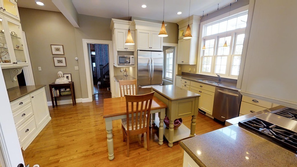 35 Renwick Road Melrose, MA 02176 - Photo 10 of 27 a kitchen with stainless steel appliances granite countertop a stove a refrigerator a dining table and chairs with wooden floor