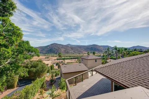 a view of house with a yard and a car park