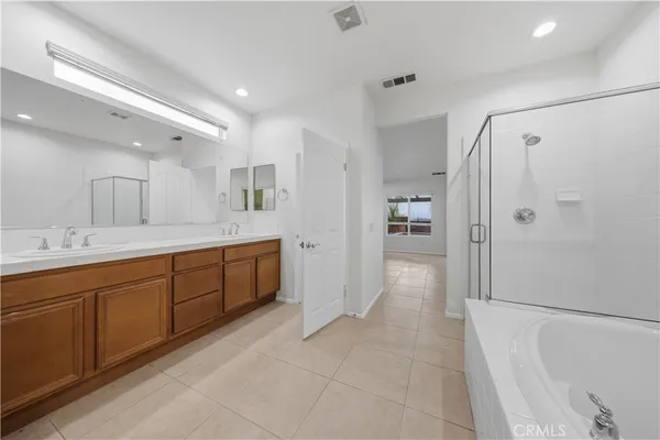 a spacious bathroom with a shower a sink and a mirror