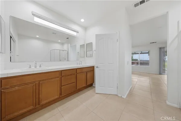 a spacious bathroom with a mirror sink and shower