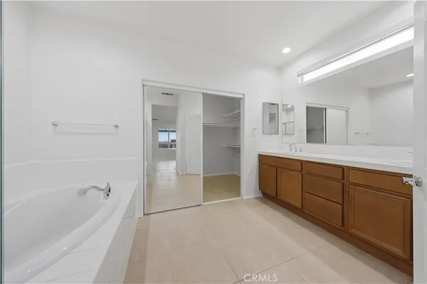 a spacious bathroom with a tub sink and mirror
