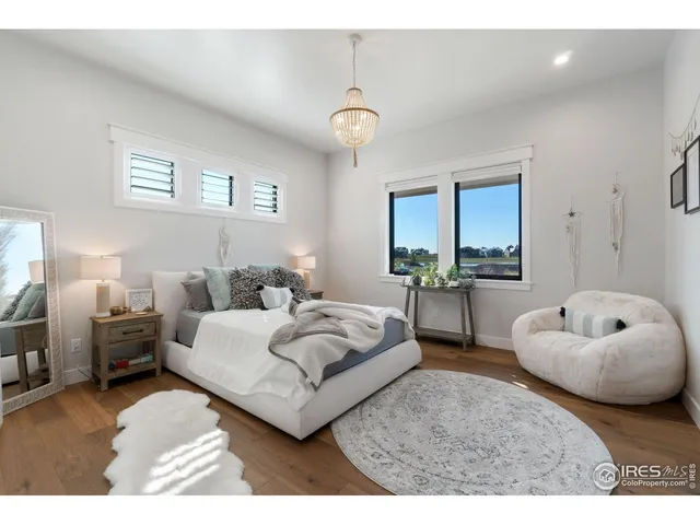 a bedroom with a bed a couch and a chandelier