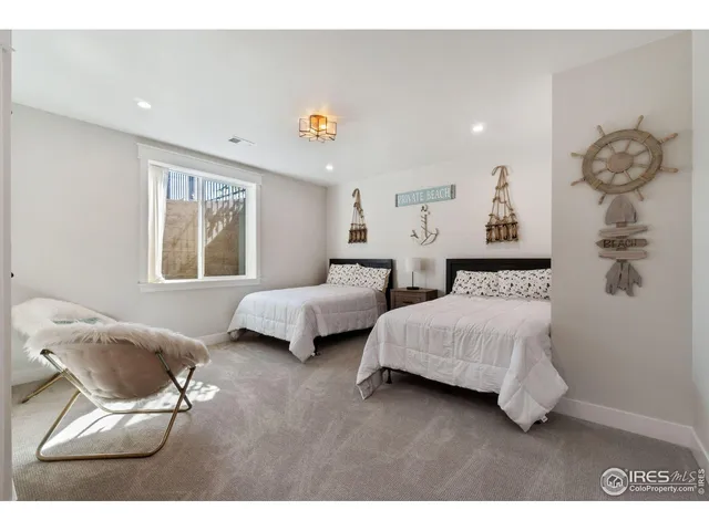 a bedroom with two beds and a chair