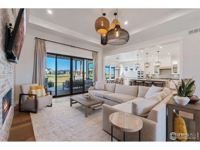 a living room with furniture a flat screen tv and kitchen view