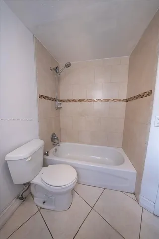 a white toilet sitting next to a bath tub and a shower