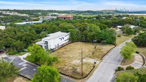 an aerial view of residential houses with outdoor space and trees