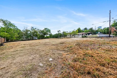 a view of a field with trees in the background