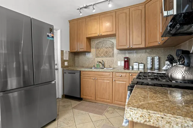 a kitchen with a refrigerator a stove a sink and cabinets