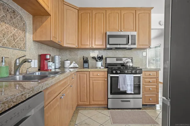 a kitchen with stainless steel appliances granite countertop a sink stove and microwave