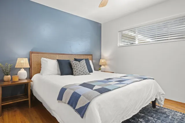 a bedroom with bed and wooden floor