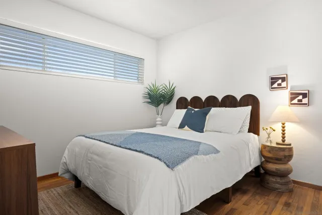 a bedroom with bed and wooden floor
