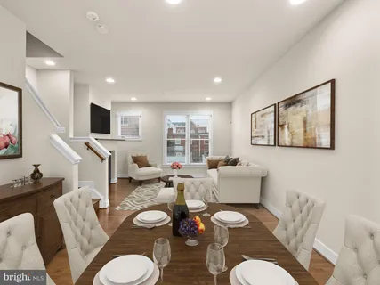 a view of a kitchen and an empty room with wooden floor a fireplace