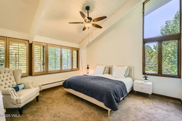 a bathroom with a granite countertop toilet a sink and a window