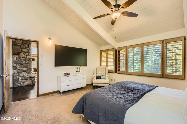 a bedroom with a bed a table and a large window