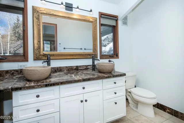 a bedroom with a bed and a dresser next to a window