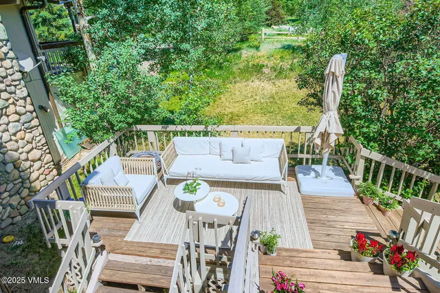 a view of a chair and table in backyard of the house